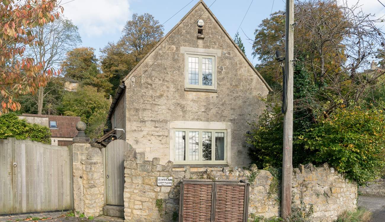 This is another view of the front of the cottage, the patio is tucked between the stone wall and the cottage, and a path leads down the side to the front door.