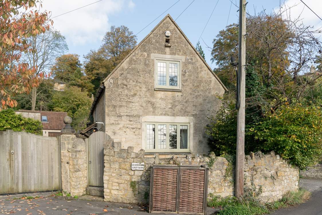 This is another view of the front of the cottage, the patio is tucked between the stone wall and the cottage, and a path leads down the side to the front door.