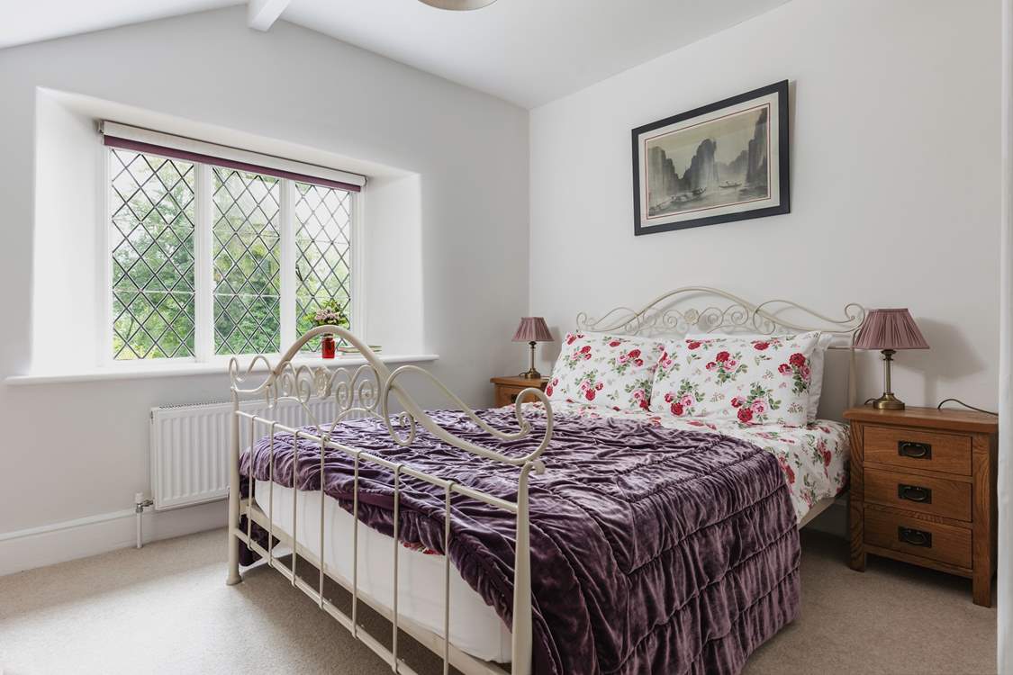 There is also a double bedroom with a view out over the terrace and the wooded hillside.