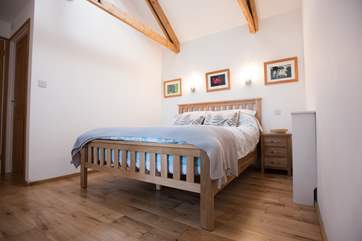 The airy bedroom has a high apex ceiling.
