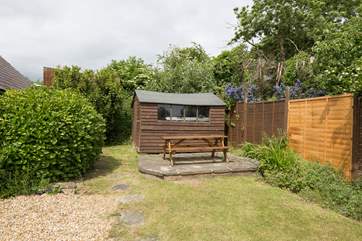The pretty seating-area at the top of the south-west facing garden with a large bench seat.