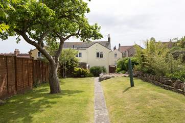 Looking from the top of the garden behind the house, down to the patio and garden-room. Please take care on the steps.