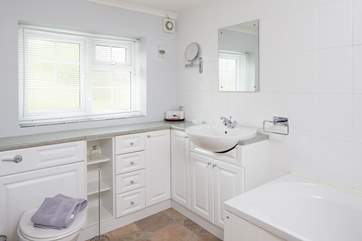 The bathroom is light and bright with a fitted shower over the bath.