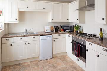 The well-equipped kitchen leads out to the garden-room.