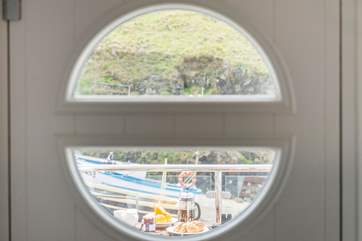 Looking out through the 'porthole' onto the balcony and fishing boats beyond.