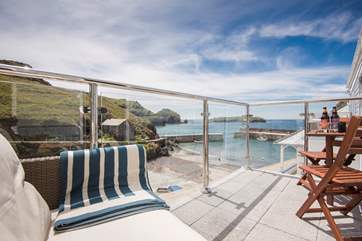 Sit a while on the rattan sofa looking out over the cove and beyond.