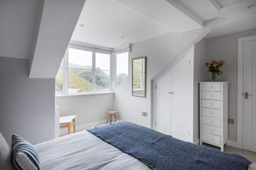 The gorgeous bedroom has wonderful views across the harbour below.