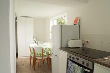The modern kitchen with dining-area, the little garden-area for the property can be seen just outside the kitchen window.