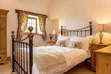 Bedroom 2 has a gorgeous brass bed, bright white linen and an en suite shower-room.