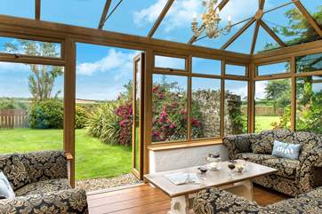 The sunny conservatory enjoys wonderful views over the garden.