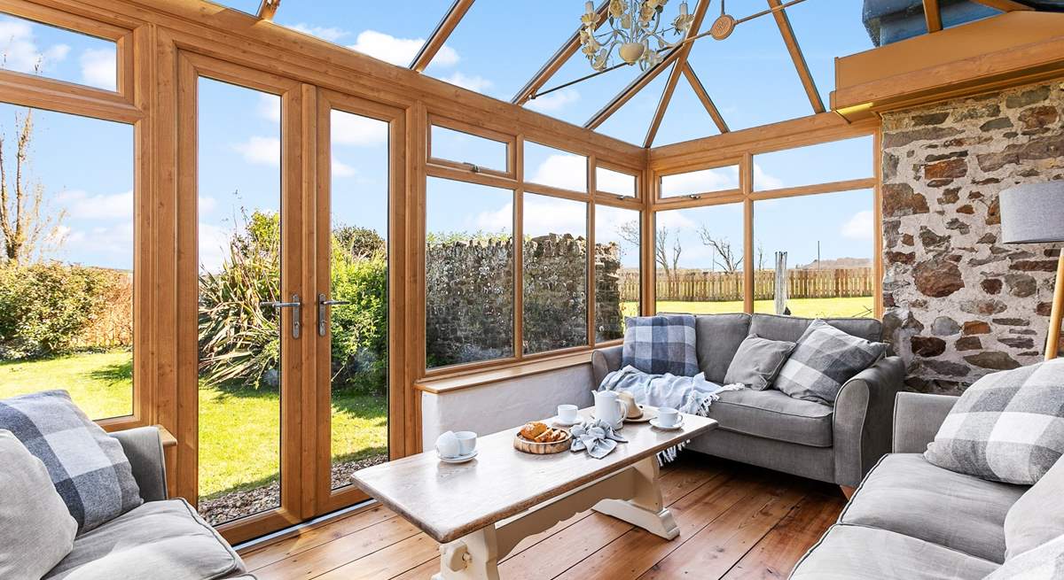 The sunny conservatory enjoys wonderful views over the garden.