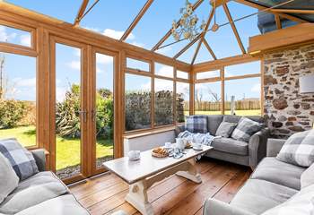 The sunny conservatory enjoys wonderful views over the garden.