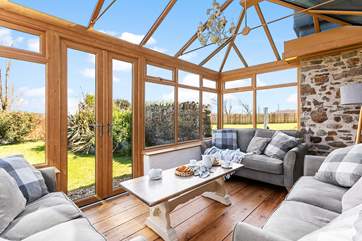 The sunny conservatory enjoys wonderful views over the garden.