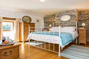 The bedroom is dual aspect with windows overlooking the garden and the front of the cottage.