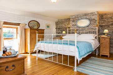 The bedroom is dual aspect with windows overlooking the garden and the front of the cottage.