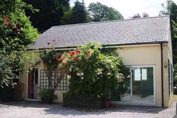 The pool-house is across the gravelled parking-area from the cottage.