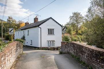 Another view of St Giles cottage on a quiet lane set back from the village, with a little river beside.