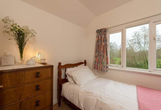The single bedroom looks out to the back of the cottage, over its garden. There are four steps up to this room.