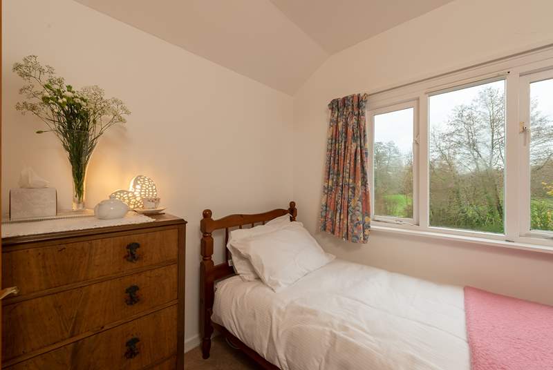 The single bedroom looks out to the back of the cottage, over its garden. There are four steps up to this room.