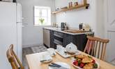 The compact kitchen is at one end of the open plan space. - Thumbnail Image