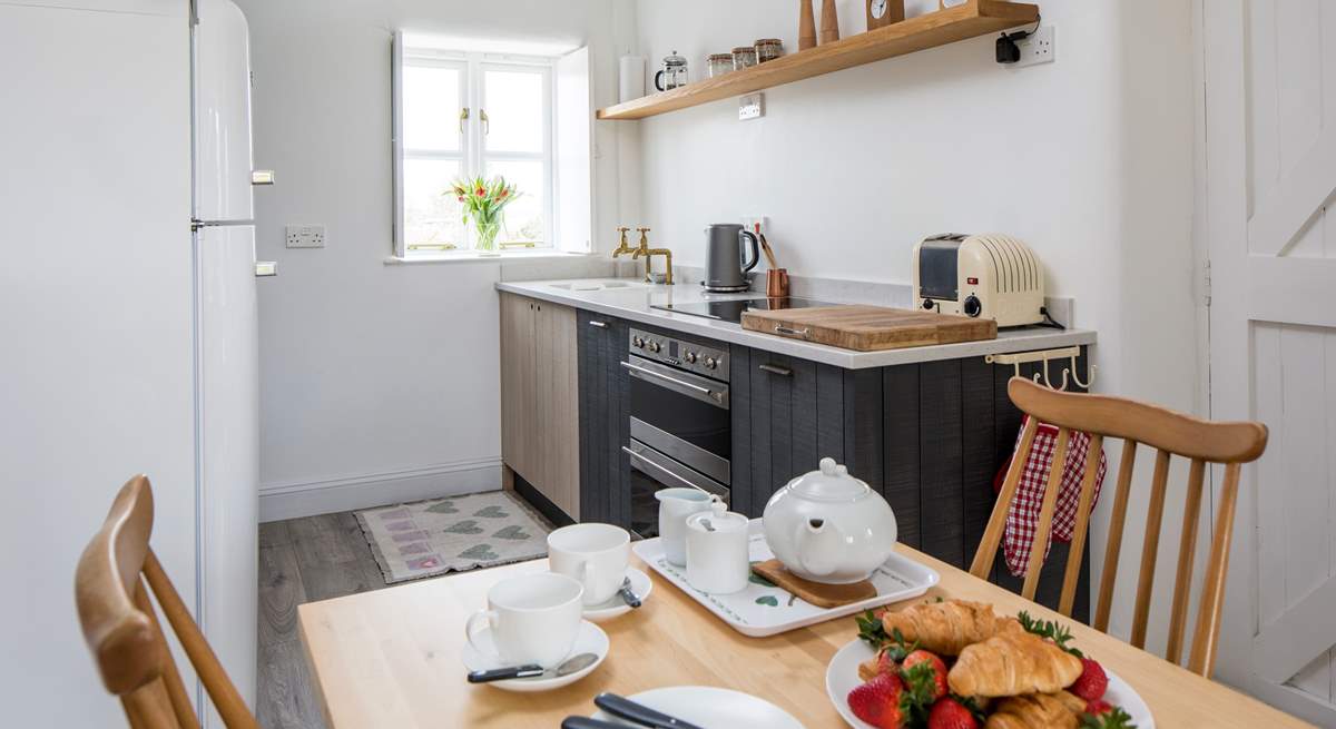 The compact kitchen is at one end of the open plan space.