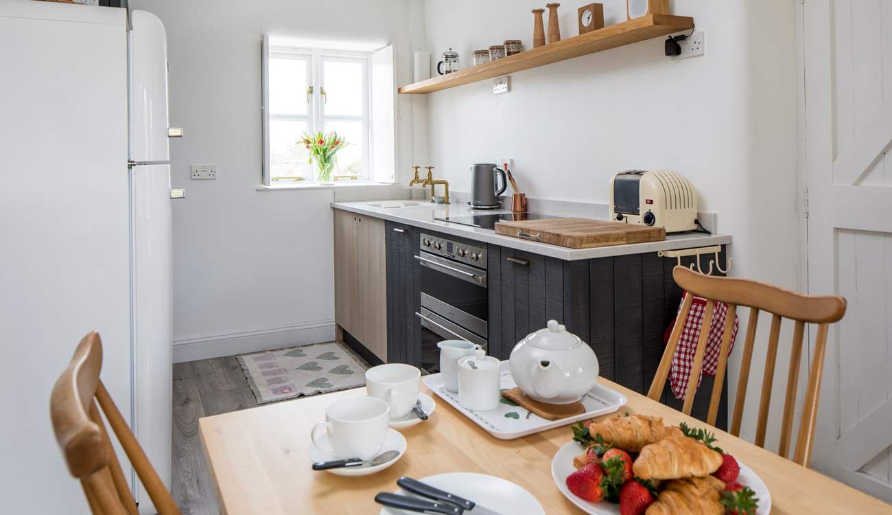 The compact kitchen is at one end of the open plan space.