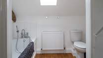 The spacious en suite bathroom has a hand held shower.