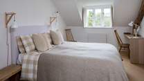 The main bedroom has a generous king-size double bed (5') with gorgeous linens and an en suite bathroom.
