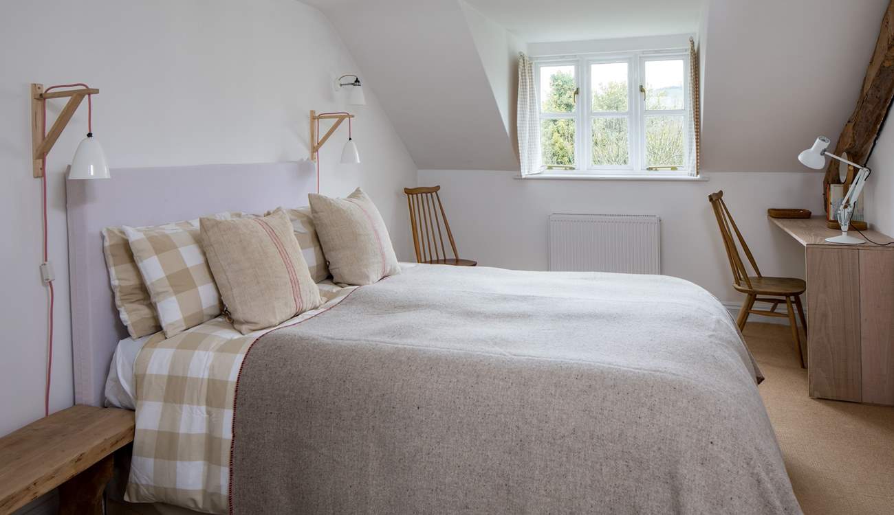 The main bedroom has a generous king-size double bed (5') with gorgeous linens and an en suite bathroom.
