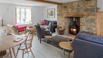 The open plan sitting/dining-room has three sofas to choose from and a cosy wood-burner.