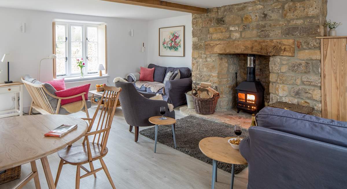 The open plan sitting/dining-room has three sofas to choose from and a cosy wood-burner.