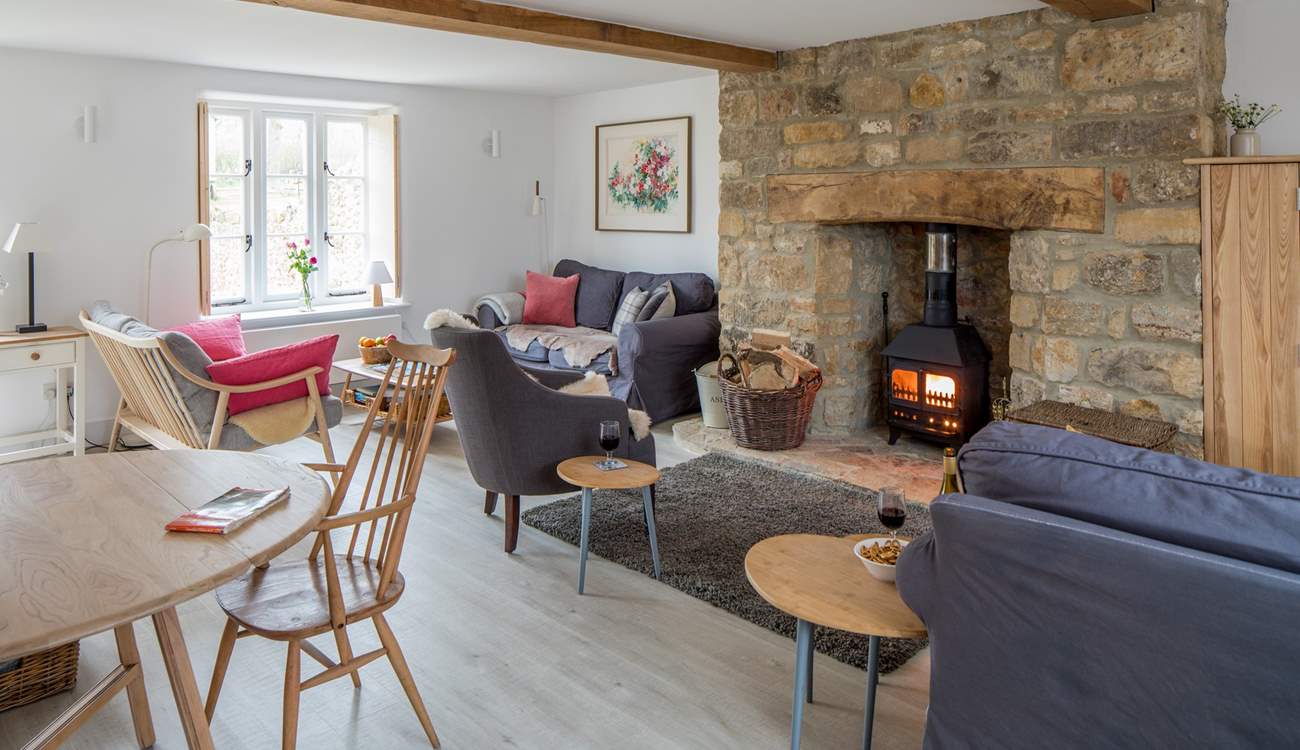 The open plan sitting/dining-room has three sofas to choose from and a cosy wood-burner.