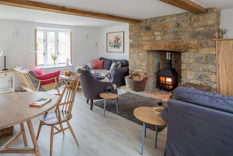 The open plan sitting/dining-room has three sofas to choose from and a cosy wood-burner.
