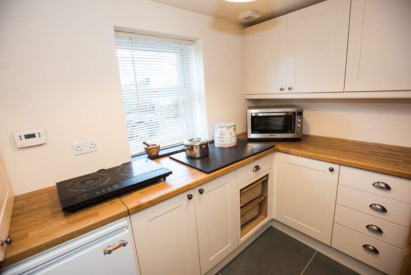 A combination microwave and double halogen hob offer additional cooking facilities in the utility-room.