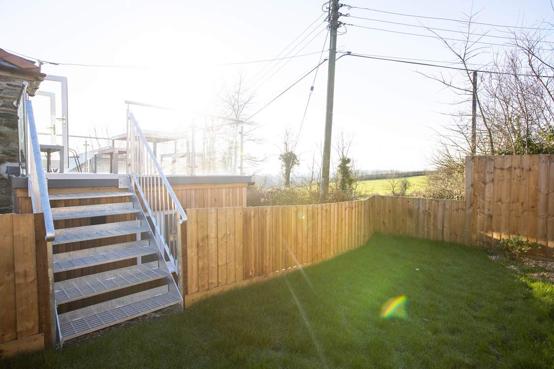 Stairs lead down from the roof terrace to the garden at the rear of the barn.