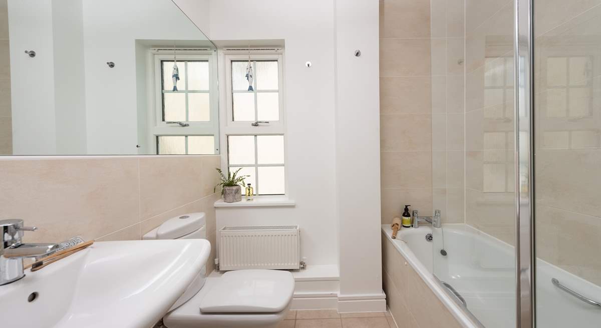 The family bathroom has a bath with shower over. 