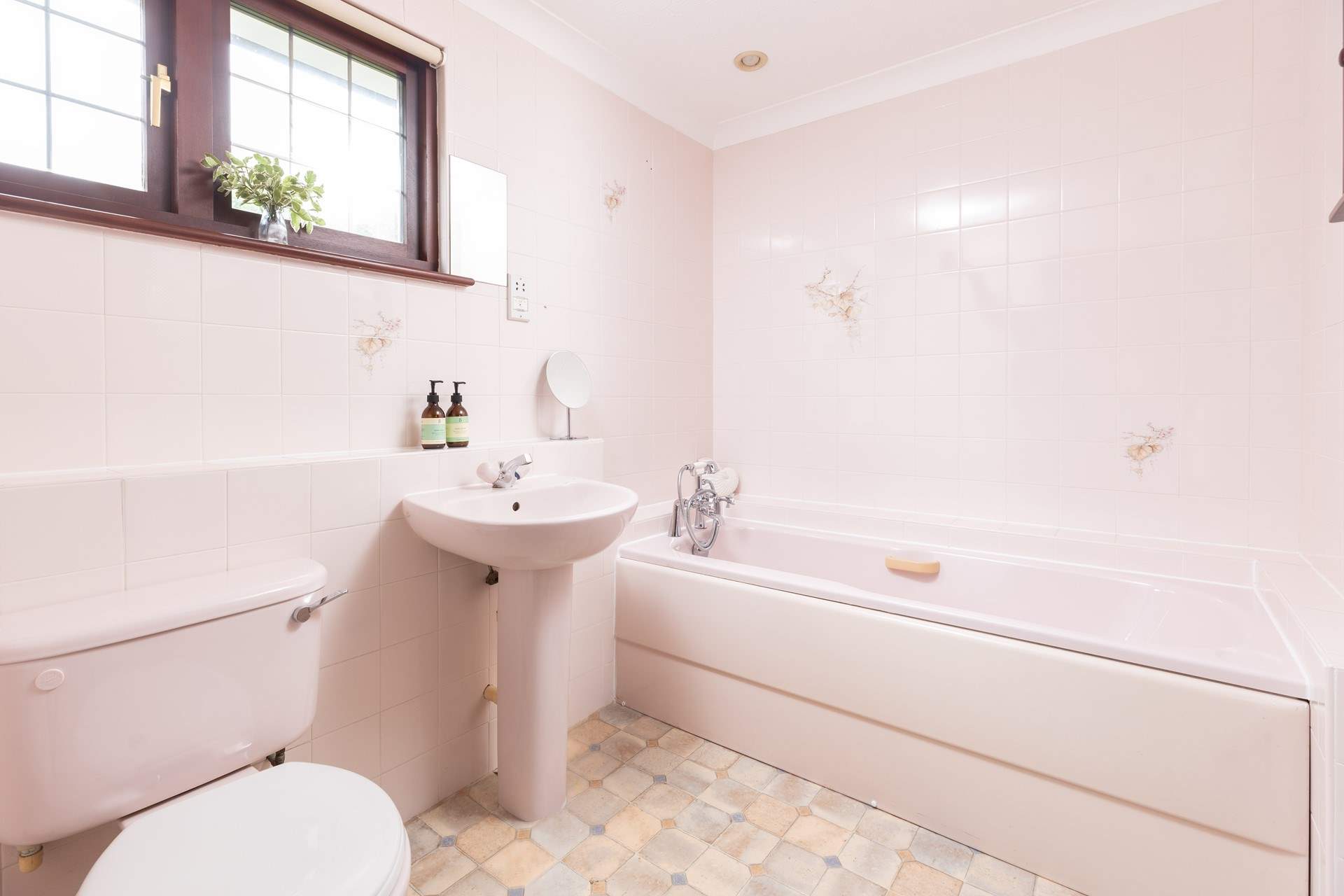 The en suite bathroom styled in pink hues. 