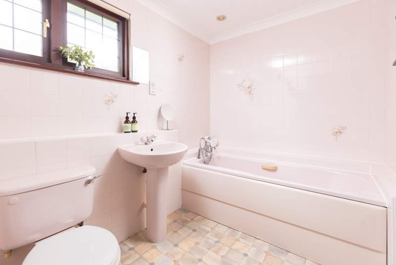 The en suite bathroom styled in pink hues. 