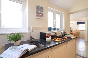 The kitchen looks through to the open plan living/dining-room.