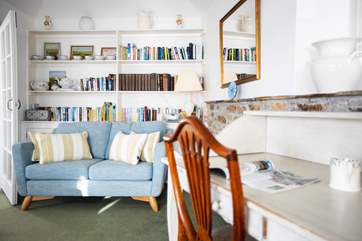 A comfy sofa and a desk for those in need of one in the living room.