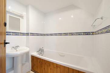 The family bathroom has a bath with hand-held shower.