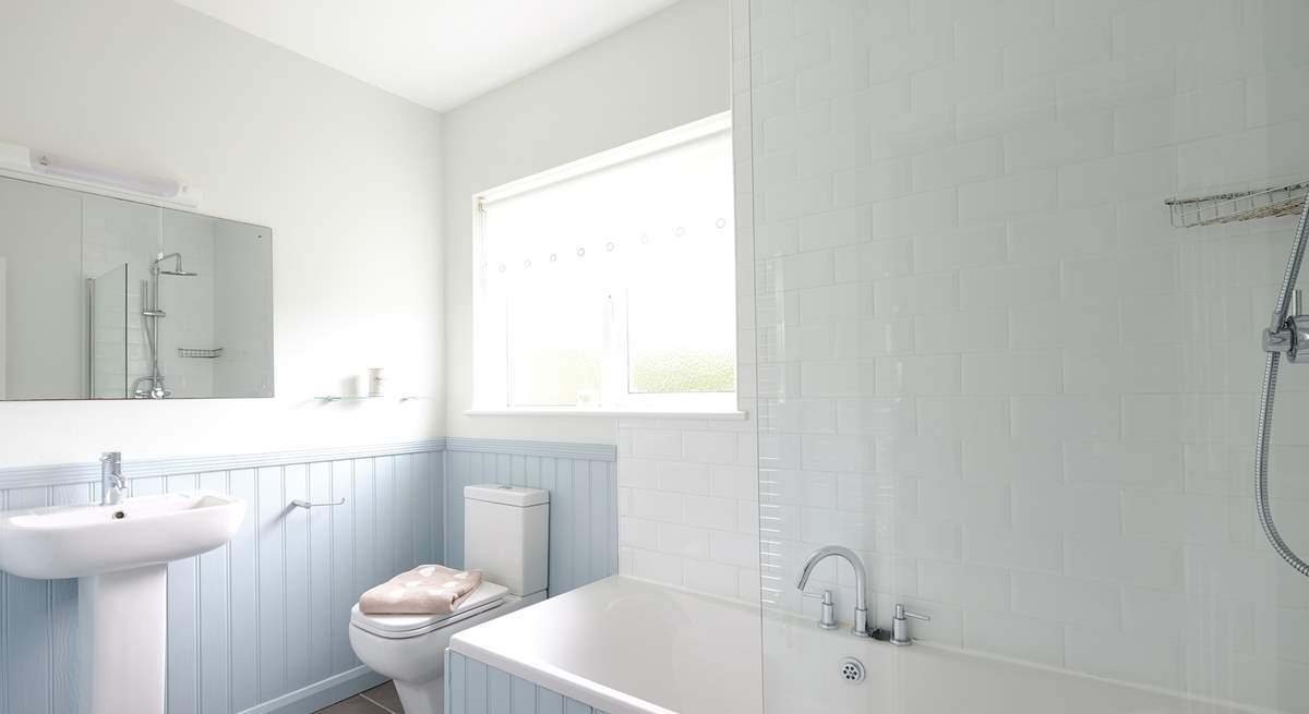 The family bathroom has a bath with shower over.