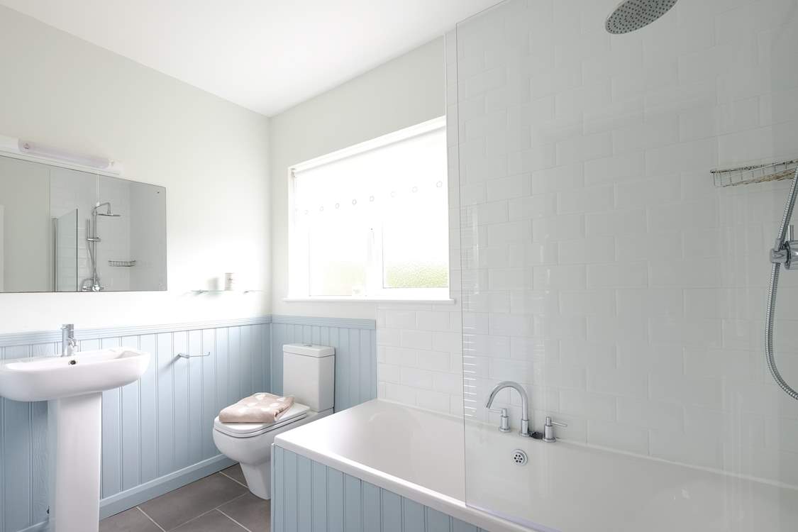 The family bathroom has a bath with shower over.