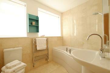 The bathroom has a bath with shower over.