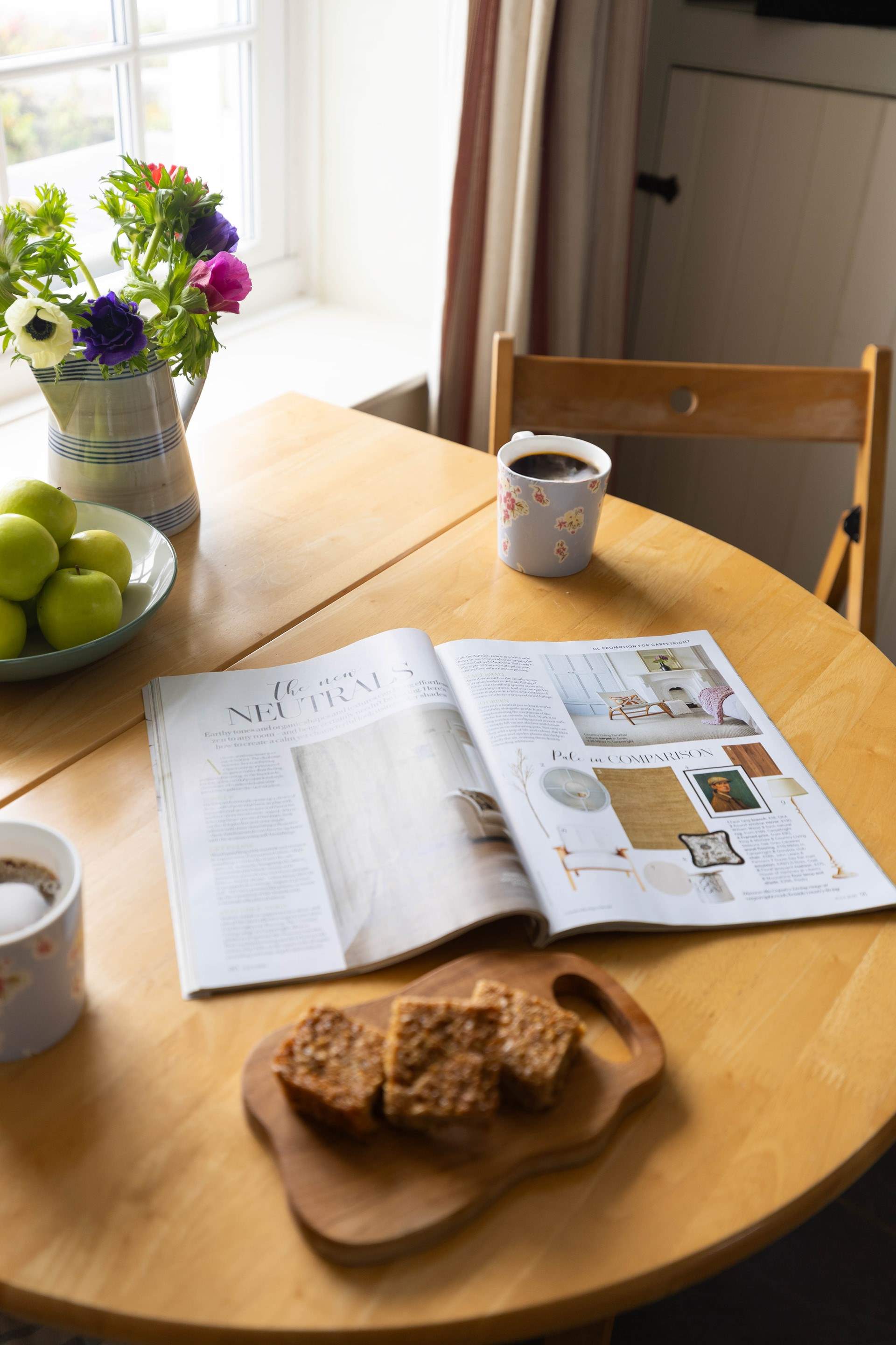 Enjoy a slow afternoon with a cup of coffee and a sweet treat at the dining table.