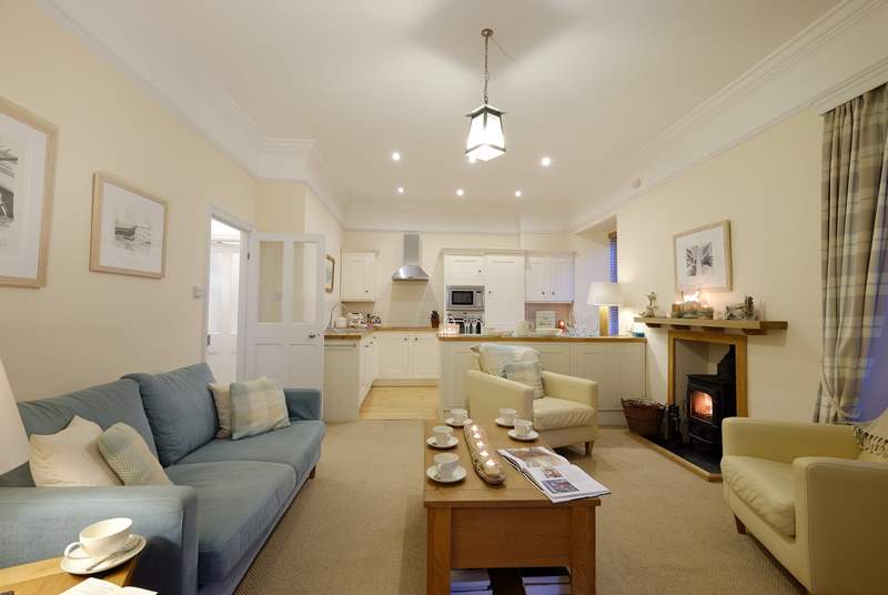 The kitchen and cosy sitting-area are open plan and warmed by a wood-burner.