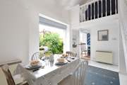 The dining-room table laid for breakfast with French windows leading out to the patio.