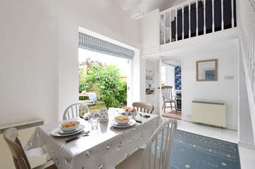 The dining-room table laid for breakfast with French windows leading out to the patio.
