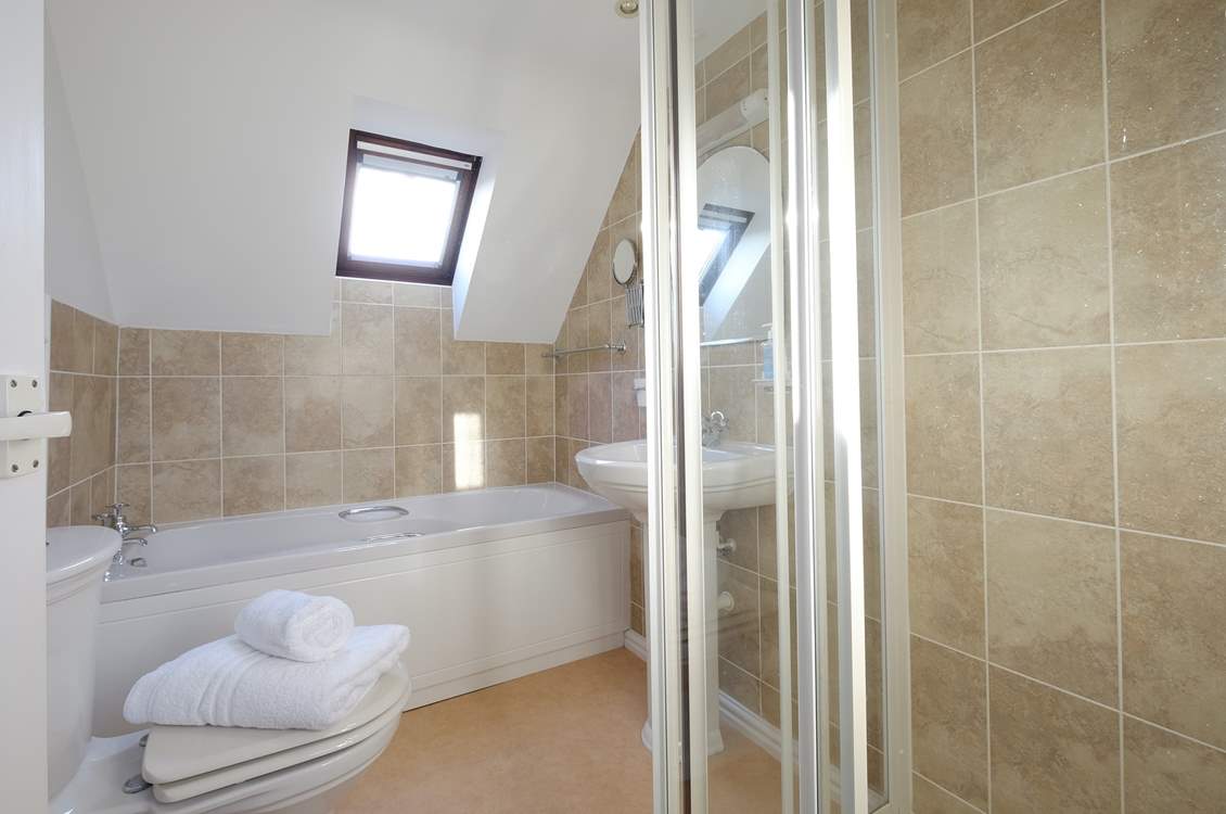 The family bathroom has a bath and a walk in. shower.