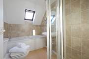 The family bathroom has a bath and a walk in. shower.